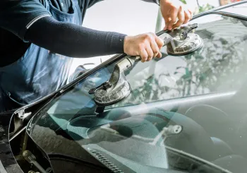 Two technicians setting a windshield with suction cups